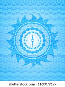 compass icon inside light blue water wave badge.