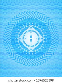 compass icon inside sky blue water style badge.