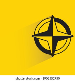 compass symbol with shadow on yellow background