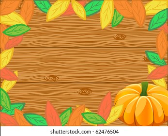 composition made of autumn leaves and pumpkin over the wooden backdrop