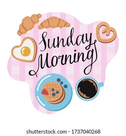 Composition on the theme of Sunday Breakfast. Lettering, coffee, croissants, eggs and waffles on a pink tablecloth.