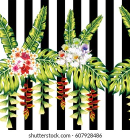 Composition from tropical bouquets of hibiscus flowers and lily and green leaves on a black white striped background. Seamless vector pattern wallpaper