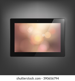 Computer tablet with bokeh background on screen. 