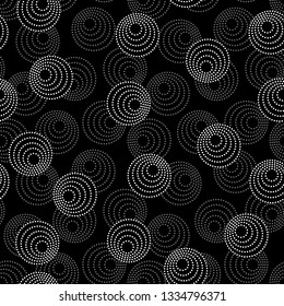 Concentric circles with dotted outline in two colors. Seamless geometric pattern on black background. Vector colorless image