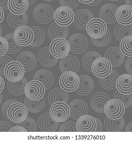 Concentric circles with dotted outline in two colors. Seamless geometric pattern on dark gray background. Vector colorless image