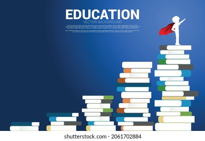 Concept background for power of knowledge. Silhouette of boy in superhero suit  standing on stack of books.