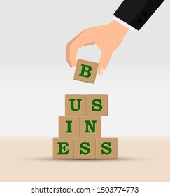 concept of building a Business. Hand is a pyramid of cubes with letters with the word BUSINESS. - Shutterstock ID 1503774773
