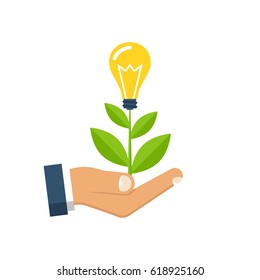 Concept growing idea. Man holding in palm hands of a growing sprout with a light bulb. Isolated on white background. Business metaphor.