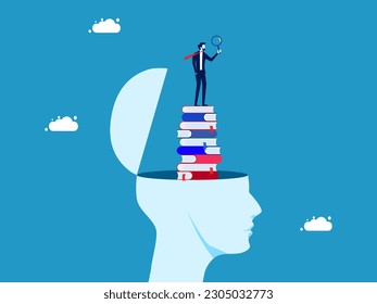 The concept of learning and analysis. Businessman with magnifying glass on stack of books in human head