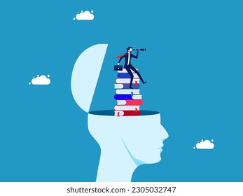The concept of learning and vision. Businessman with binoculars on stack of books in human head