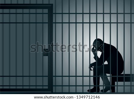 Concept of the prison with the arrest of a criminal. The prisoner is sitting in his cell and desperate, holding his head in his hands.
