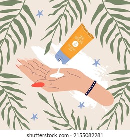 The concept of sun protection. Pressed sunscreen on the hand surrounded by palm leaves.
