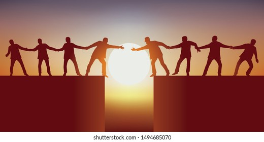 Concept of teamwork with two groups of men, separated by a chasm that tries to meet by holding each other to successfully overcome the obstacle.