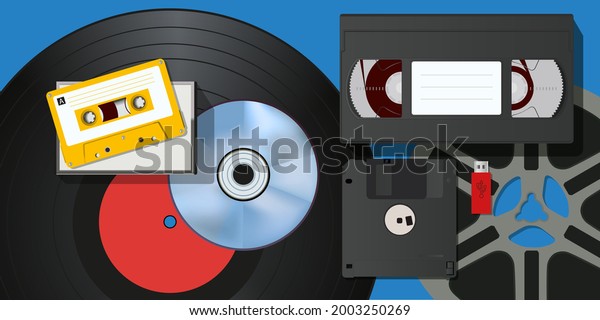 Concept of vintage, with a collection of video and\
audio recording equipment, such as cassettes, vinyl disc, USB stick\
and film reel.
