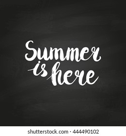 Conceptual hand drawn phrase Summer is here on chalkboard. Lettering design for posters, t-shirts, cards, invitations, stickers, banners, advertisement. Vector.