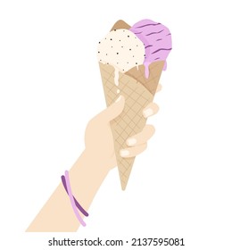 A cone with ice cream balls in a woman's hand. 