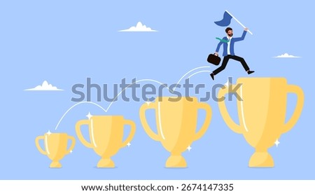 Confident businessman leaps from a small trophy to a larger one. Concept of using small wins as motivation to achieve bigger success and goals.