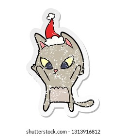 confused hand drawn distressed sticker cartoon of a cat wearing santa hat