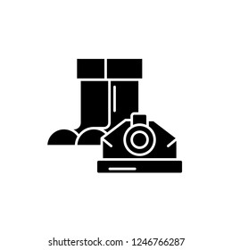 Construction boots and helmet black icon, vector sign on isolated background. Construction boots and helmet concept symbol, illustration 