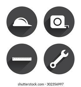 Construction helmet and wrench key tool icons. Ruler and tape measure roulette sign symbols. Circles buttons with long flat shadow. Vector