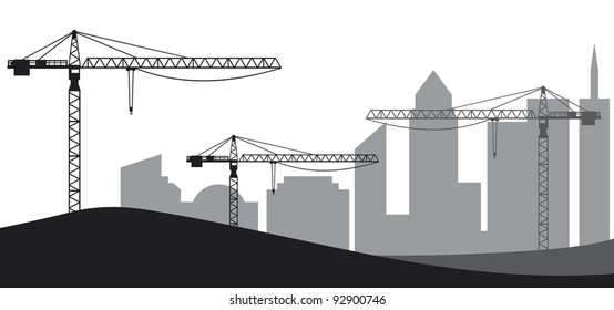 Construction site, cranes and silhouette of the city