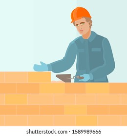 construction worker dressed in blue uniform and orange helmet holds trowel in hand and builds a brick wall