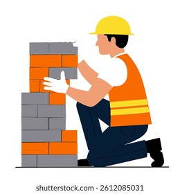 A construction worker kneels to stack bricks, wearing a hard hat and safety vest.