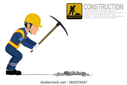 A construction worker is using pickaxes for digging hole on the ground.
