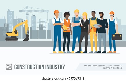 Construction workers and engineers posing together at the construction site, machinery and crane on the background