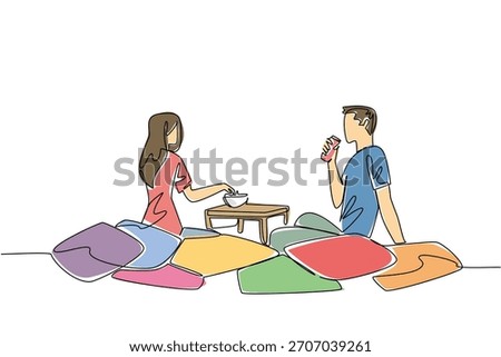 Continuous line draw of couple sitting on colorful floor cushions. Creative cozy setup, snacks, and relationship happiness while in living spaces for extra comfort and fun, National Movie Night event