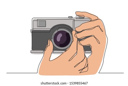 continuous line drawing of hand holding photo camera making pictures