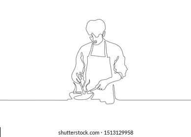 Continuous line drawing of a male cook in an apron holding a spoon which interferes with food in the pan. A man stands the stove and cooks. It can be used for animation. Vector