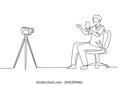 Continuo dibujo de una línea blogger árabe reseña el nuevo smartphone en la cámara dslr. Canal de transmisión en vivo. Hombre portando un teléfono móvil para el producto de revisión. Ilustración vectorial de diseño de líneas simples