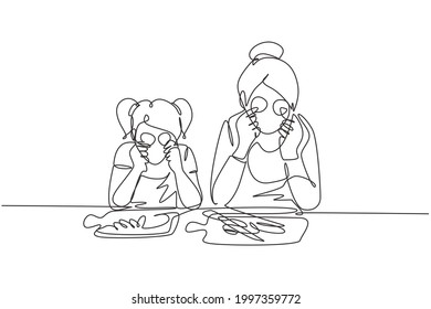 Continuous one line drawing cute little girl and her beautiful mom are holding slices of cucumber and smiling while cooking in kitchen at home. Single line draw design vector graphic illustration
