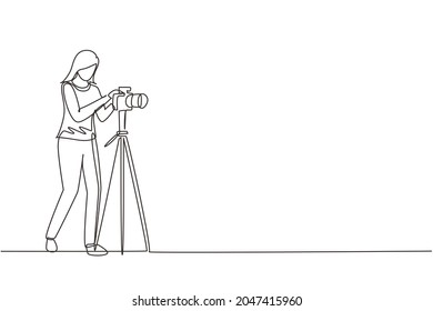 Una línea contínua dibujando a una fotógrafa tomando fotos usando equipo profesional. Mujer con cámara fotográfica. Equipo fotográfico de estudio. Ilustración vectorial de diseño de líneas simples