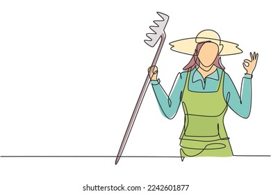 Continuous one line drawing female farmer with gesture okay wearing straw hat and carrying rake to work on the farm. Success business concept. Single line draw design vector graphic illustration