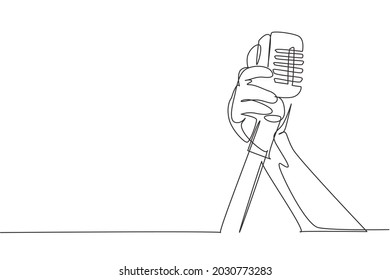 Continuous one line drawing hand holding a retro microphone over white background. Rock music live concert with old microphone. Mic for sing a song. Single line draw design vector graphic illustration