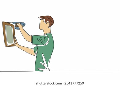 Dibujo continuo de una línea: un hombre taladra la pared con un taladro e instala un marco decorativo de madera. Hágalo usted mismo para la satisfacción interior. Día Nacional del bricolaje. Ilustración vectorial de diseño de dibujo de línea única