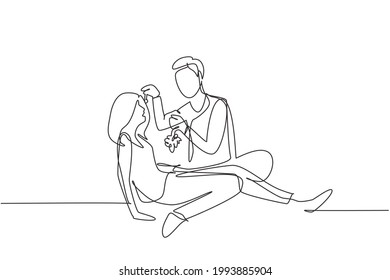 Continuous one line drawing romantic couple having picnic in summer park. Relaxing together sitting on the ground and men feeding grapes to women. Single line draw design vector graphic illustration