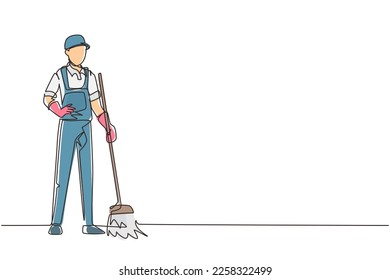 Continuous one line drawing smiling young male janitor standing in uniform, sweeping the floor with broom, professional cleaning, home and office service. Single line draw design vector illustration