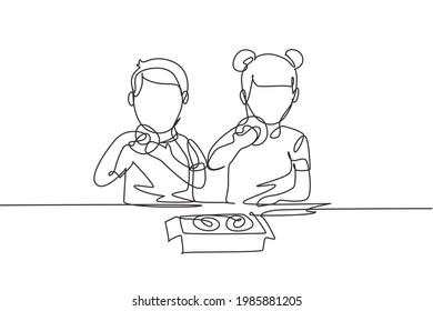 Continuous one line drawing two boy and girl having donuts meal with hand around table. Happy and enjoy breakfast at home. Tasty and healthy food. Single line draw design vector graphic illustration