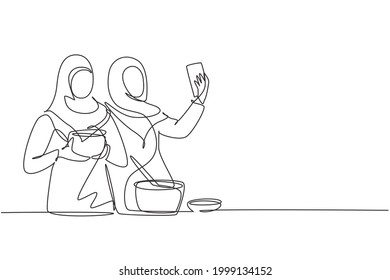 Continuous one line drawing two Arab woman taking selfie or making video call using her smartphone while cooking fresh salad. Healthy food concept. Single line draw design vector graphic illustration