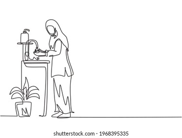 Continuous one line drawing a woman in a hijab washes her hands in the sink, there is a soap dish near the faucet and pot of plants under the sink. Single line draw design vector graphic illustration.