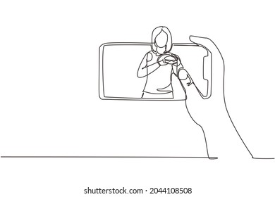 Continuous one line drawing woman food blogger eating burger while creating new content video for her channel by using smartphone. Food review blogger. Single line draw design vector illustration