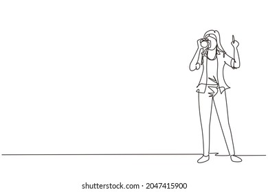 Continuous one line drawing woman photographer using professional camera in the studio. Female standing and giving count gesturing for taking pictures. Single line draw design vector illustration