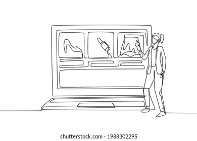 Continuous one line drawing young woman choosing shopping items on a giant laptop screen. Digital lifestyle with internet and gadgets concept. Single line draw design vector graphic illustration