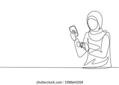 Continuous one line drawing young Arabian woman typing entering credit card code on smartphone around desk. Digital lifestyle and payment concept. Single line draw design vector graphic illustration