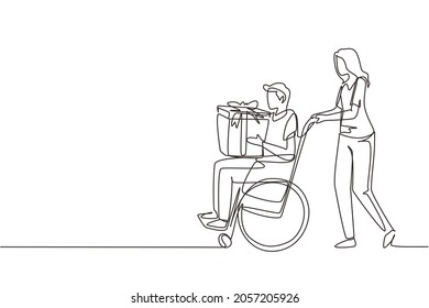 Una línea continua dibujando a jóvenes y hombres discapacitados en silla de ruedas. Mujer comprando y regalando una caja al hombre. Rehabilitación de personas con discapacidad, asistencia a personas con discapacidad. Vector de diseño de tracción de línea única