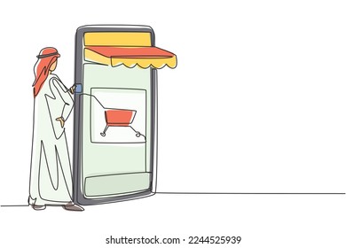 Continuous one line drawing young Arab man inserting credit card into canopy smartphone screen with shopping cart. E-shop, digital payment concept. Single line draw design vector graphic illustration