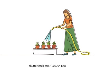 Continuous one line drawing young woman watering potted plants with hose. Gardening, greenhouse, botanical garden, flowers growing, plant nursery concept. Single line draw design vector illustration